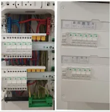 Deux coffrets côte à côte dans un mur : à gauche un tableau de répartition câblé, protections modulaires et barrette de terre verte ; à droite un coffret de communication avec ses réglettes.